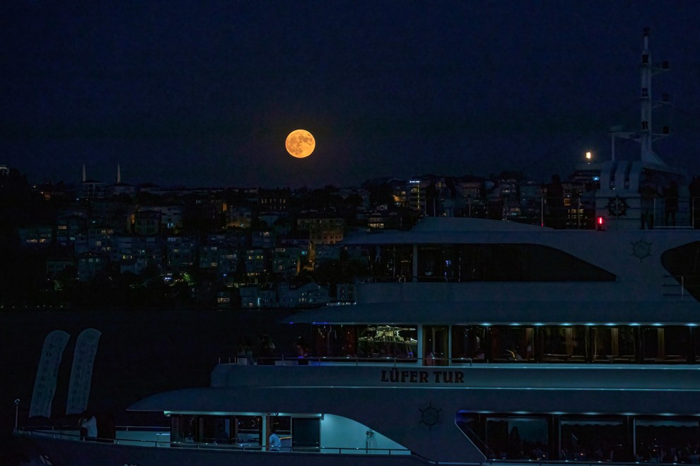 Superluna nad pristaniščem v Istanbulu je zasenčila razkošne jahte, zasidrane v pristanišču.