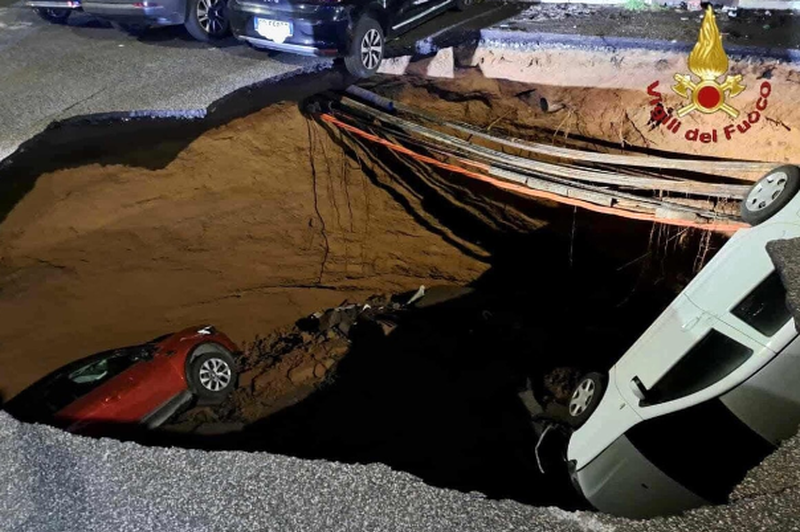 Kot da bi se odprl pekel: nenadoma v tleh zazevala ogromna luknja in "pogoltnila" dve vozili (VIDEO) (foto: Vigili del Fuoco/Posnetek zaslona)