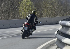 Huda nesreča: motorist izgubil nadzor in obtičal pod osebnim vozilom